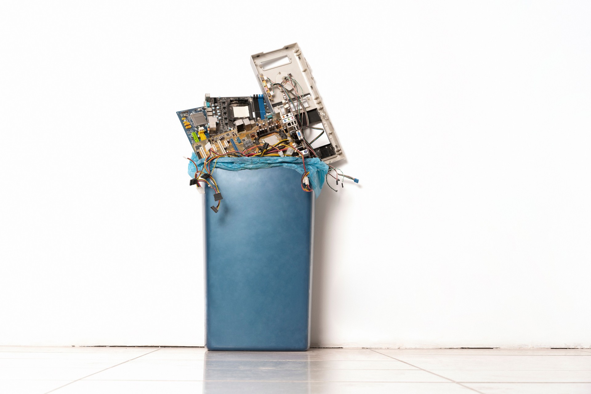 Plastic trash can full with pile of used, obsolete electronics